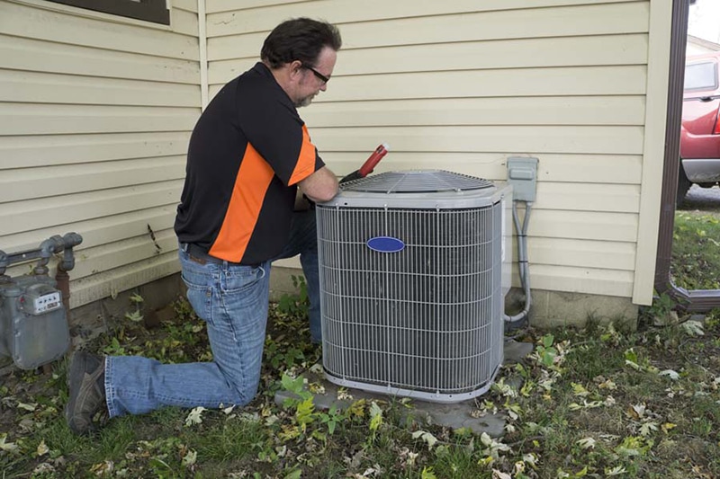 HVAC Installation 101: What to Expect When Upgrading. Repairman installing an AC unit.