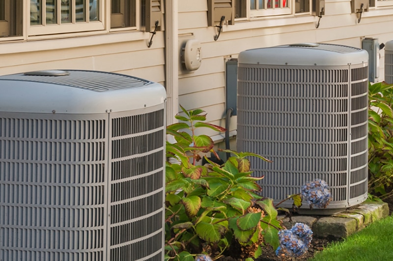 Is Upgrading Your Seattle HVAC System Worth It in 2024? Two air conditioning units outside.
